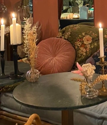 Détail réel du Beaulieu : bougies, fleurs séchées et banquette à coussins fleuris